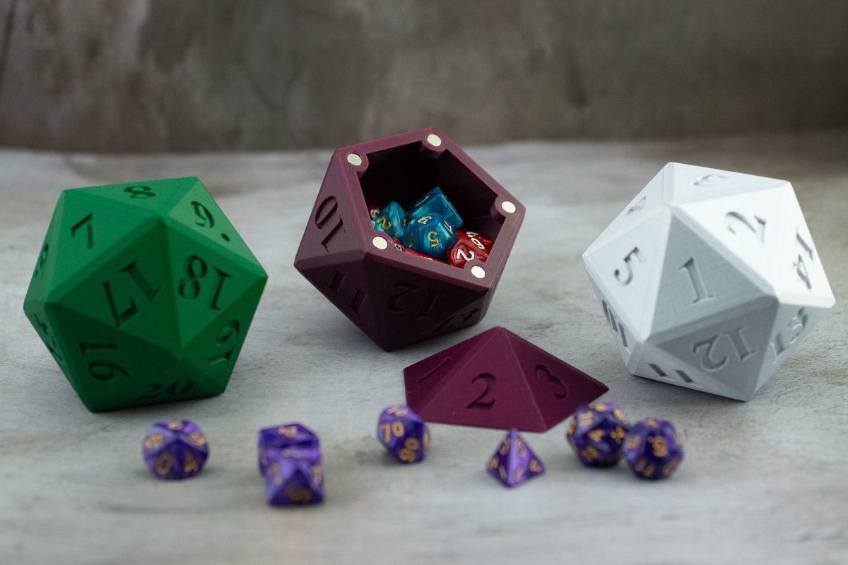 Green, maroon and white D20 dice vaults, the maroon one open with dice inside