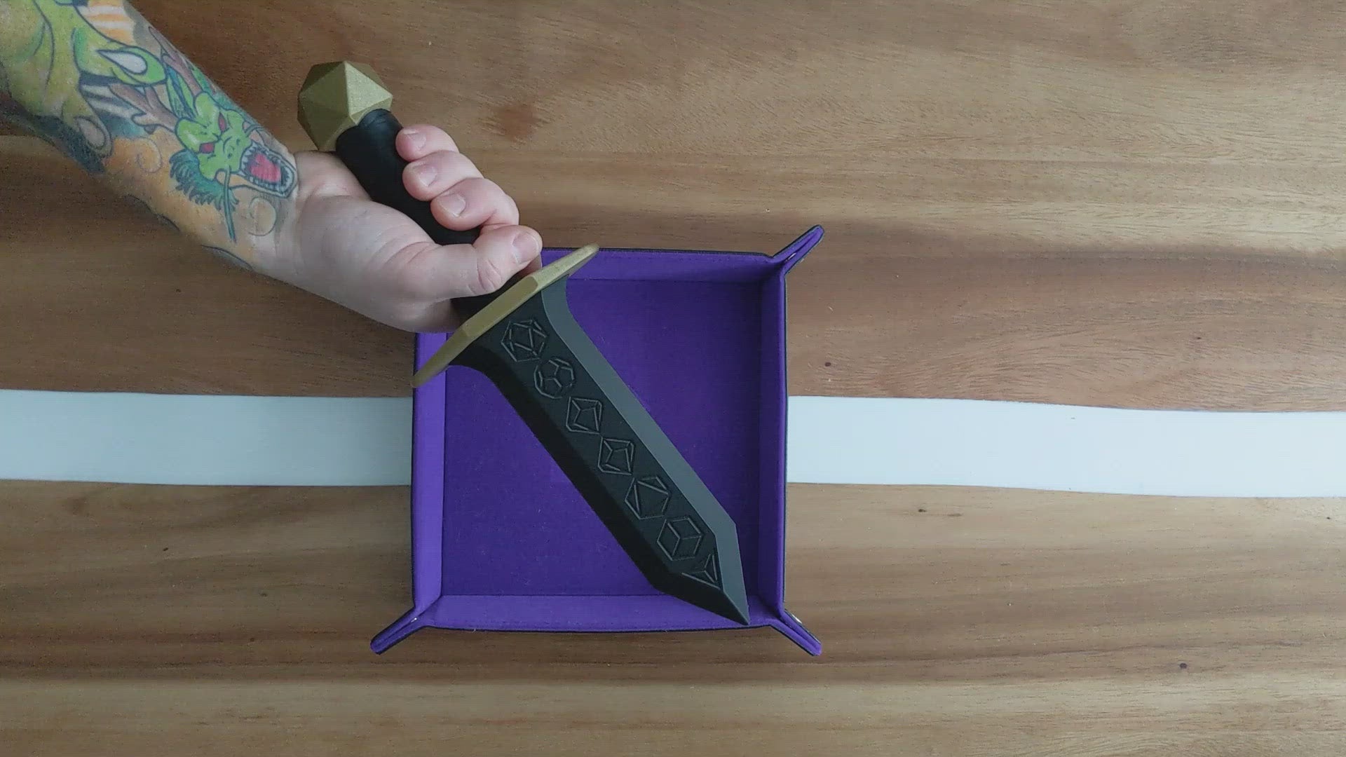 Demonstrating our dice dagger in action - each dagger holds a set of RPG dice in the blade, with a removable pommel for extra storage in the handle!