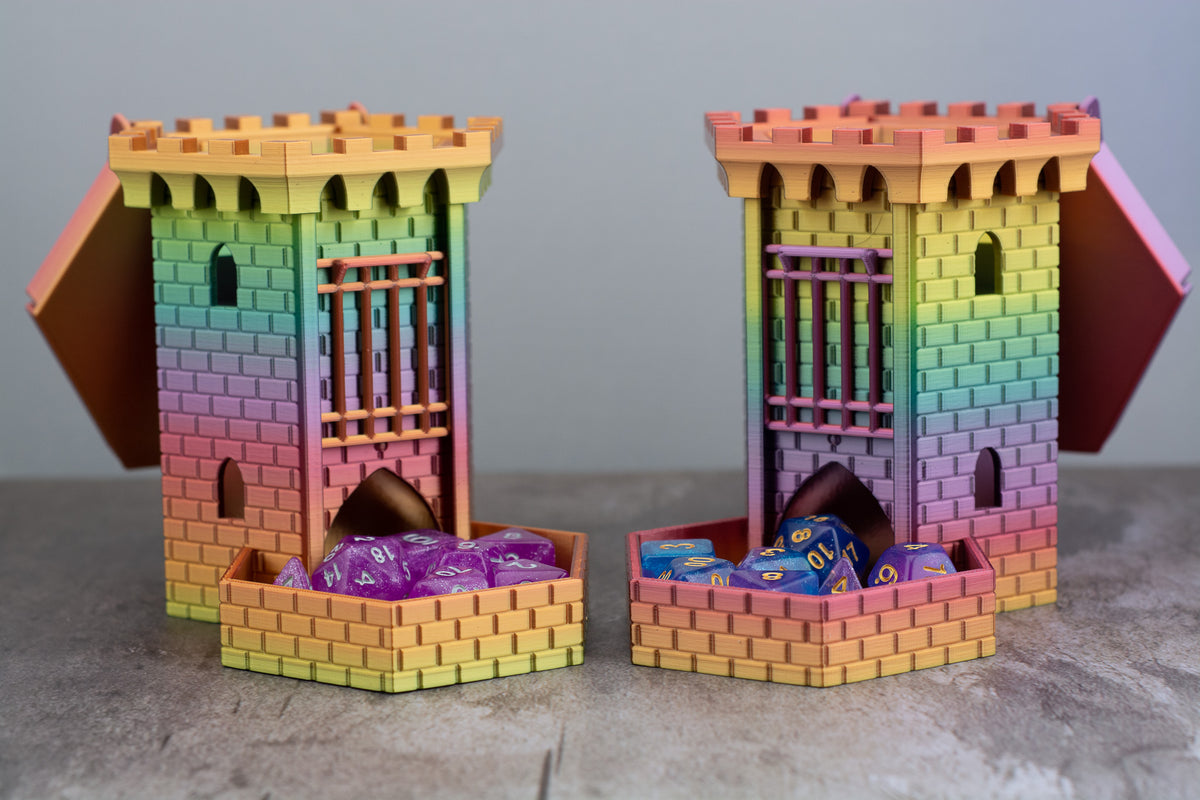 Two rainbow castle dice towers with dice in their trays