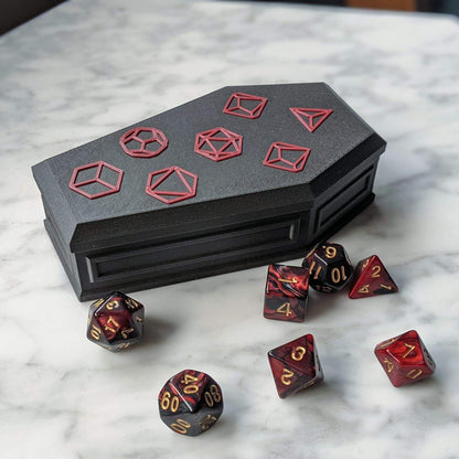 Closed coffin dice vault with red and black dice scattered around it