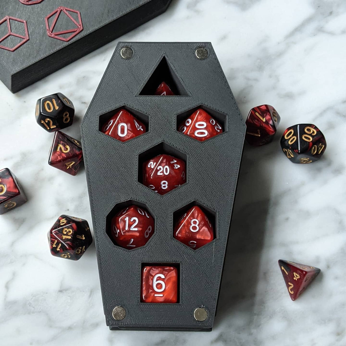 Coffin dice vault base holding a full set of red and black polyhedral dice