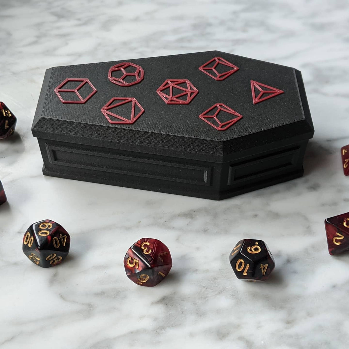 Closed coffin dice vault on a marble table with three dice in front