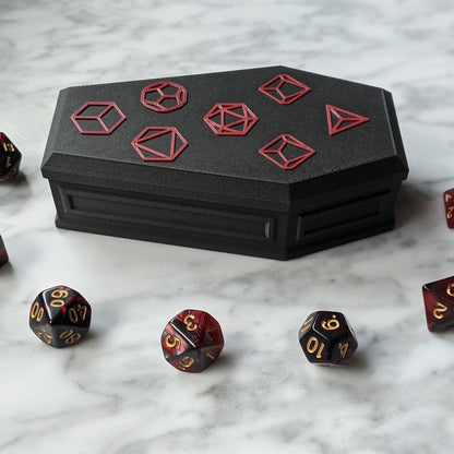 Closed coffin dice vault on a marble table with three dice in front