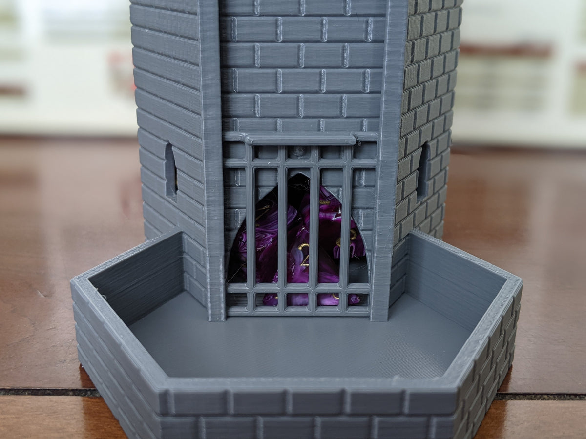 Close-up of the dice tower's portcullis gate and tray holding purple dice