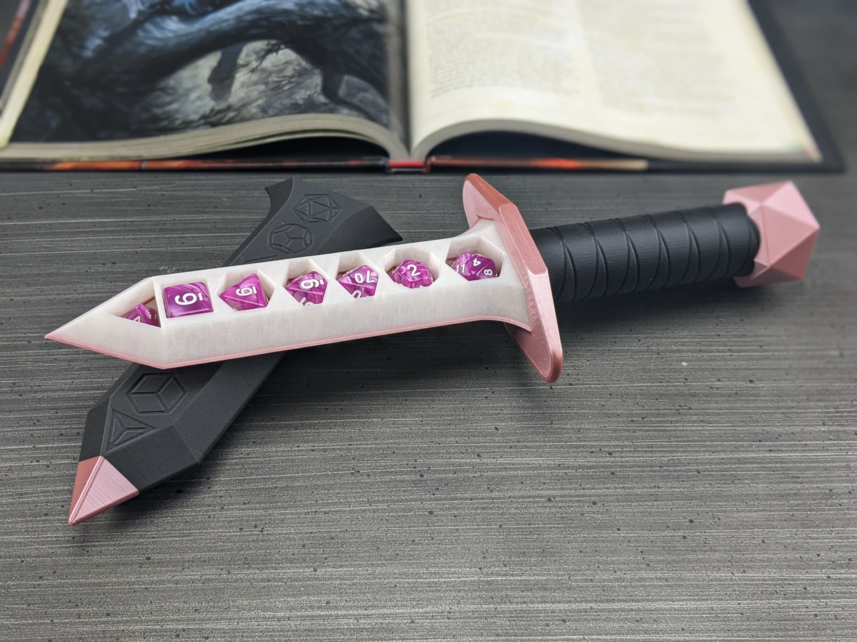 Pink and black dice holding dagger with pink dice in the blade, next to an open rulebook